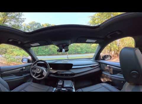 Interior view of 2027 Buick Enclave Sport Touring showing dashboard, leather seats, and infotainment touchscreen.