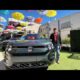 2027 Volkswagen Atlas SEL Premium R Line in front of a modern building, priced at $58,135