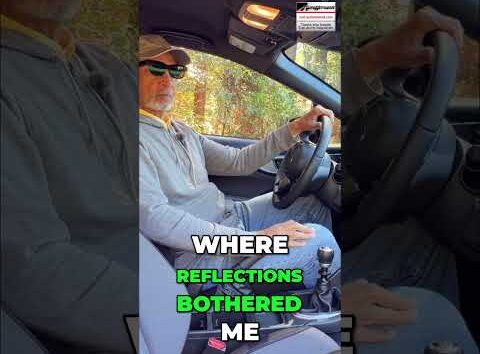 Close-up of a car dashboard and windshield showing heavy glare and distracting reflections from bright sunlight.