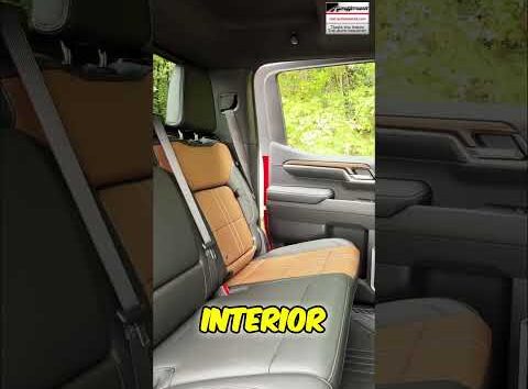 Person sitting in a car interior testing windshield visibility and checking cabin space for an auto buying guide.