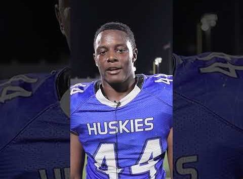 Elijah Eche, a Houston Defender athlete, smiling and looking at the camera during an interview.