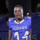 Elijah Eche, a Houston Defender athlete, smiling and looking at the camera during an interview.