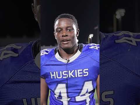 Elijah Eche, a Houston Defender athlete, smiling and looking at the camera during an interview.