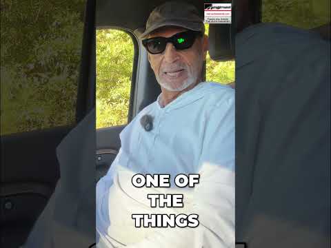 Land Rover Defender parked outdoors, showcasing exterior design for a buyer's guide video review.