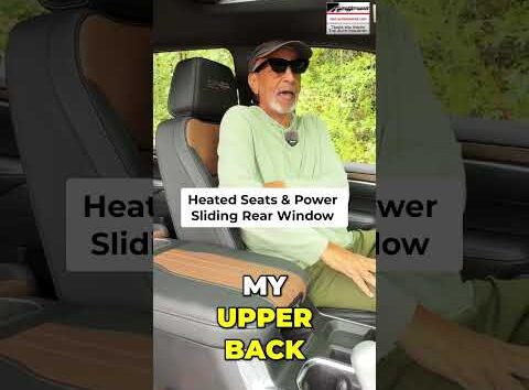 Close-up of a modern truck interior showing heated seat controls and a sliding rear window button for enhanced comfort.