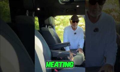 Interior of a luxury SUV featuring plush leather captain's chairs and heated seat controls in a modern vehicle cabin.