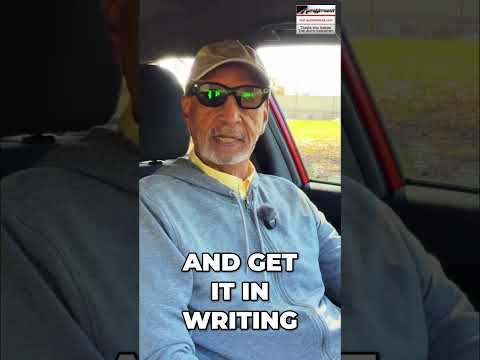 Car buyer sitting at a dealership desk looking concerned while a salesperson explains monthly payment options.