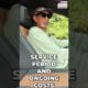 Driver smiling with hands off the steering wheel while using Super Cruise hands-free driving technology on a highway.