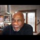 Al McFarlane hosting an interview segment for BlackPressUSATV with studio lighting and professional broadcast equipment.