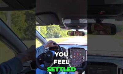 Subaru WRX driver adjusting the seat headrest for comfort and ergonomics in an AutoNetwork car review video.