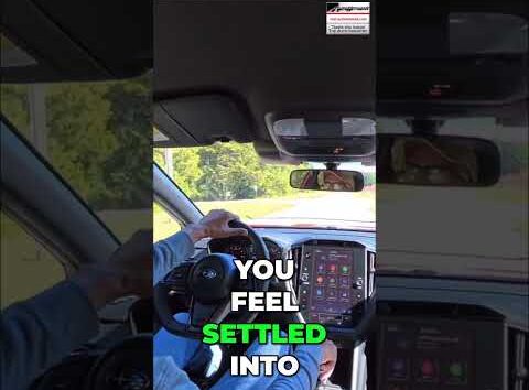 Subaru WRX driver adjusting the seat headrest for comfort and ergonomics in an AutoNetwork car review video.