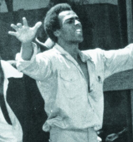 Black Panther Party co-founder Huey P. Newton raises his arms above a crowd of supporters. In his 1971 essay “Black Capitalism Re-Analyzed,” Newton argues that power means the ability of people to control their own destiny.