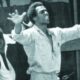 Black Panther Party co-founder Huey P. Newton raises his arms above a crowd of supporters. In his 1971 essay “Black Capitalism Re-Analyzed,” Newton argues that power means the ability of people to control their own destiny.