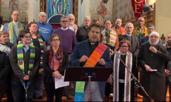 Metro Detroit faith leaders stand behind Rev. Paul Perez of the United Methodist Church downtown Detroit. Photo Samuel Robinson