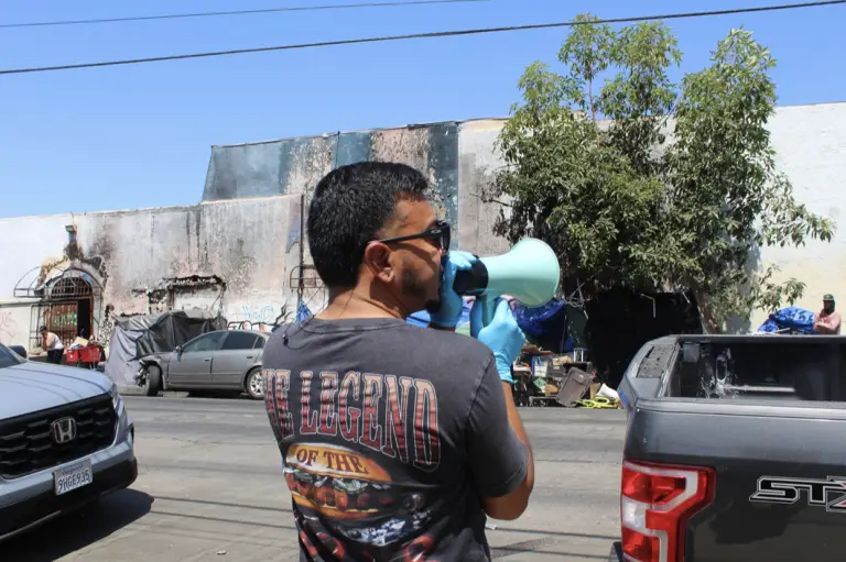 Members of St. John’s street medicine team use a megaphone to mobilize patients during street outreach. Photo by Marion Apio