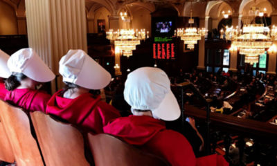 Women dressed as Handmaids, characters from Margaret Atwood's dystopian novel, "The Handmaid's Tale," watch as Rep. Kelly Cassidy, D-Chicago, presents her arguments in favor of the Reproductive Health Act on the floor of the House in Springfield (Capitol News Illinois photo by Rebecca Anzel).